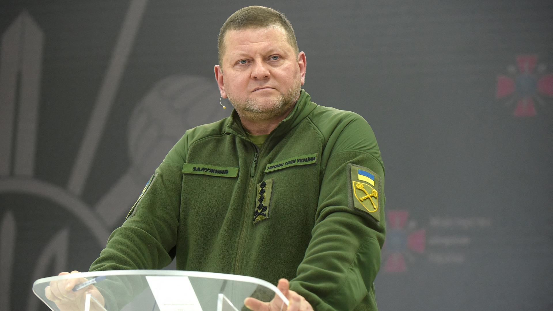 Der ehemalige Oberbefehlshaber der ukrainischen Streitkräfte, Walerij Saluschnyi steht in grüner Militärkleidung an einem Stehpult. 