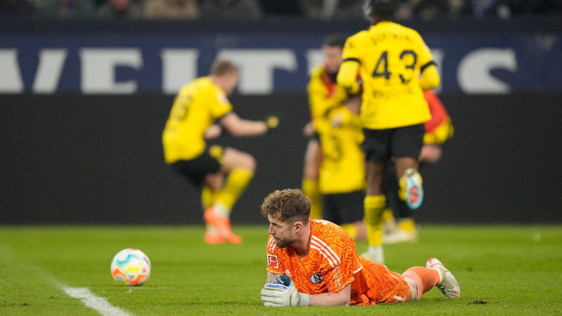 Der Torhüter von Schalke, Fährmann, liegt auf dem Rasen. Neben ihm der Ball, der ins Tor rollt.
