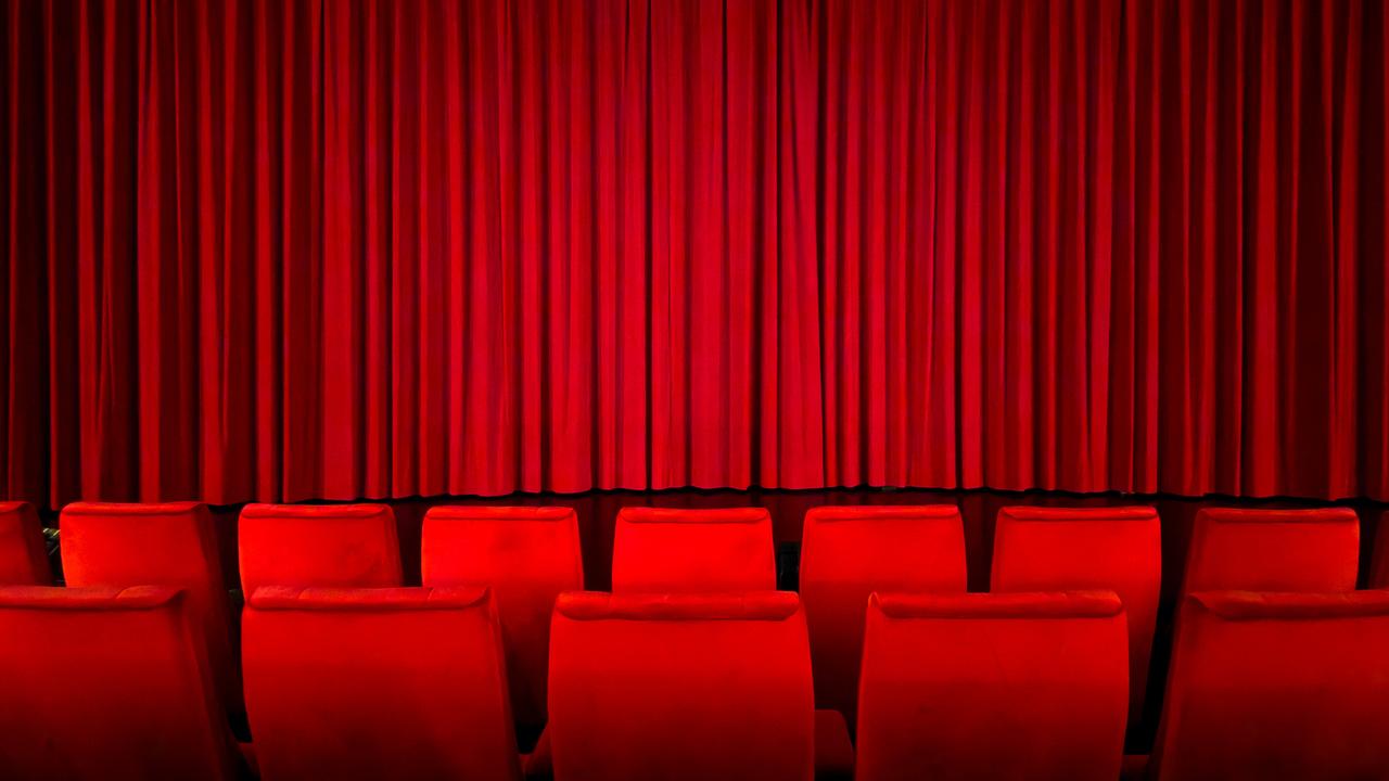 Ein roter Vorhang in einem Kinosaal vor der Vorstellung.