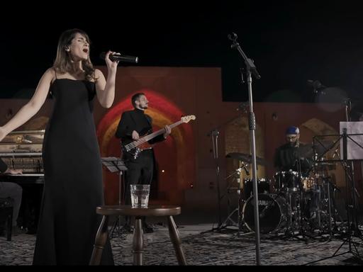 Das Foto zeigt die iranische Sängerin Parastoo Ahmadi bei ihrem Live-Konzert im Iran - ohne Kopftuch, in einem schwarzen Kleid.