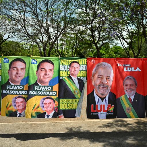 Wahlplakate von Lula da Silva und Flávio Bolsonaro nebeneinander an einer Wand.