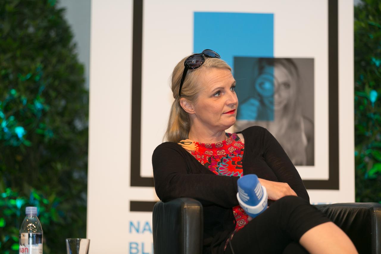 Eine Frau mit einem Mikrofon. Es ist die Kabarettistin Barbara Ruscher.