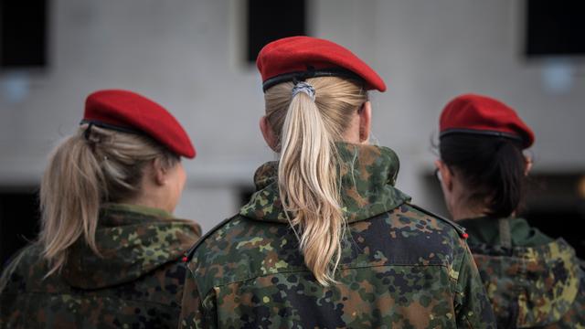 Drei Soldatinnen stehen mit dem Rücken zur Kamera. Sie tragen Bundes-Wehr-Uniformen.