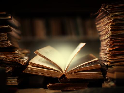 EIn Buch liegt offen auf dem Schreibtisch in der Bibliothek, die Seiten scheinen sich zu bewegen und erhellen die Umgebung durch ein magisches Leuchten