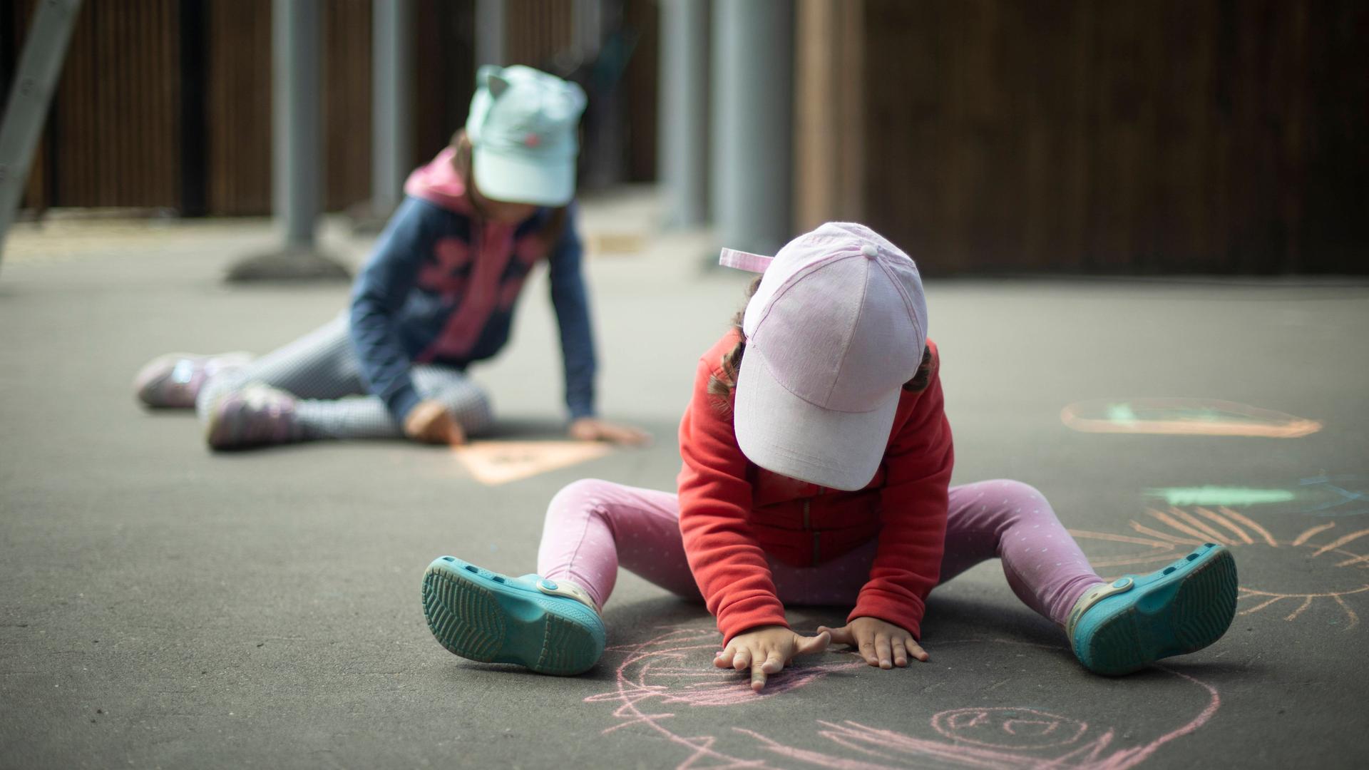 Kinder spielen und malen Kreide auf Asphalt.