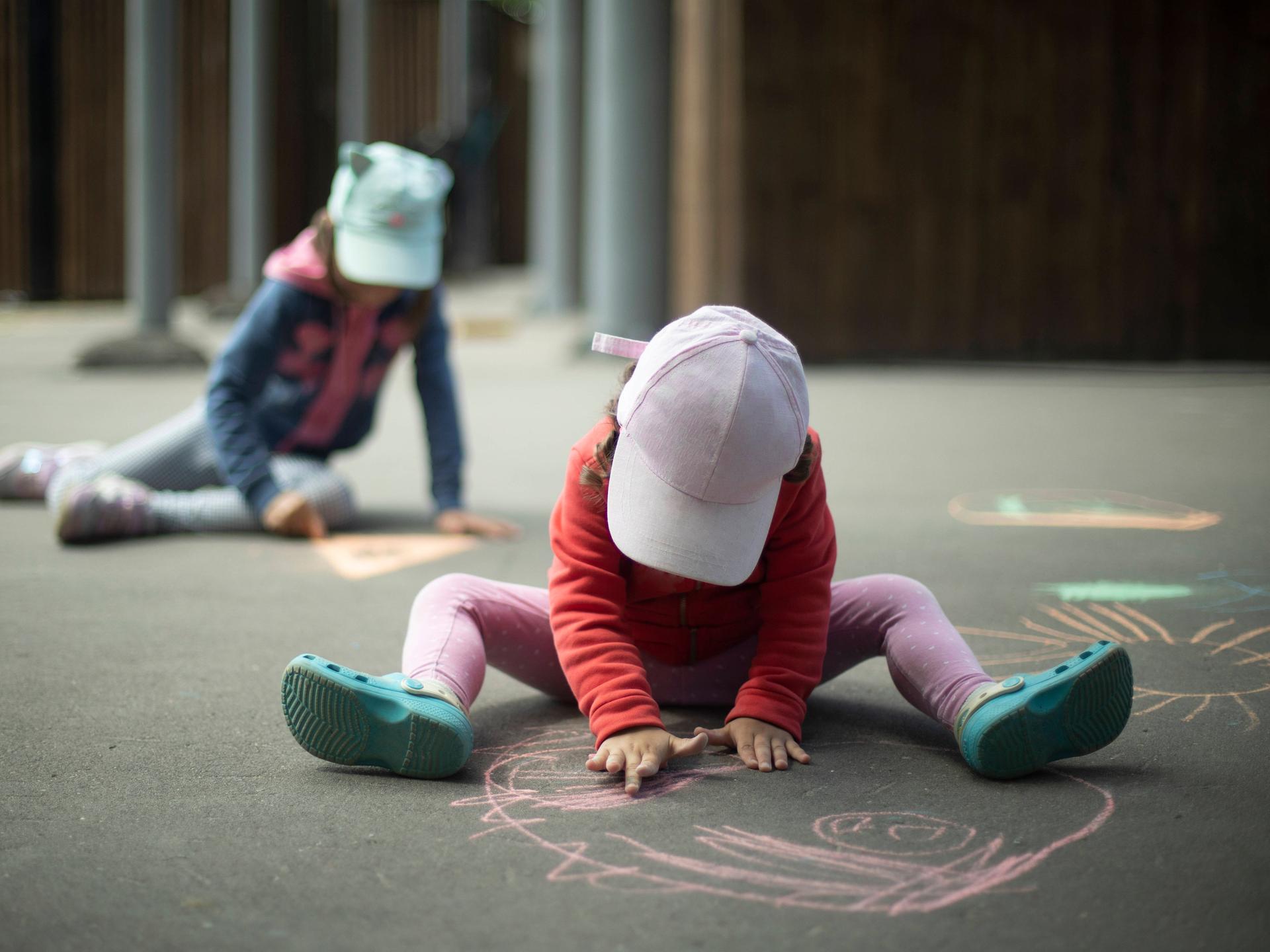 Kinder spielen und malen Kreide auf Asphalt.