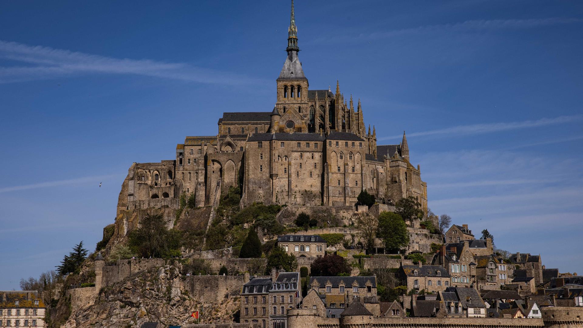 Die Abteikirche Mont Saint-Michel tront über mittelalterlichen Häusern inmitten des Meeres