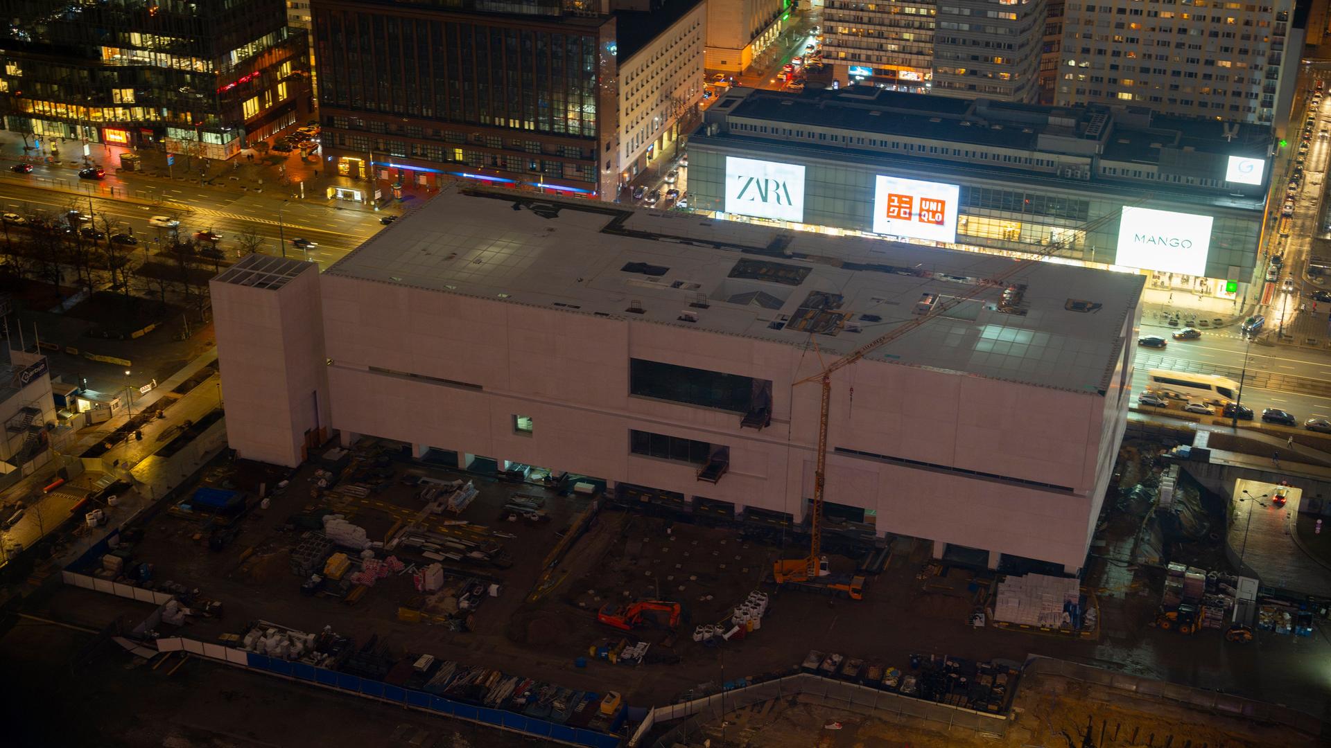 Ein Blick in der Nacht von oben auf das neue, weiße Gebäude des Museums für zeitgenössische Kunst in Warschau. Dahinter Leuchtreklame an einer Straße. Ein Blick in der Nacht von oben auf das neue, weiße Gebäude des Museums für zeitgenössische Kunst in Warschau. Dahinter Leuchtreklame an einer Straße.