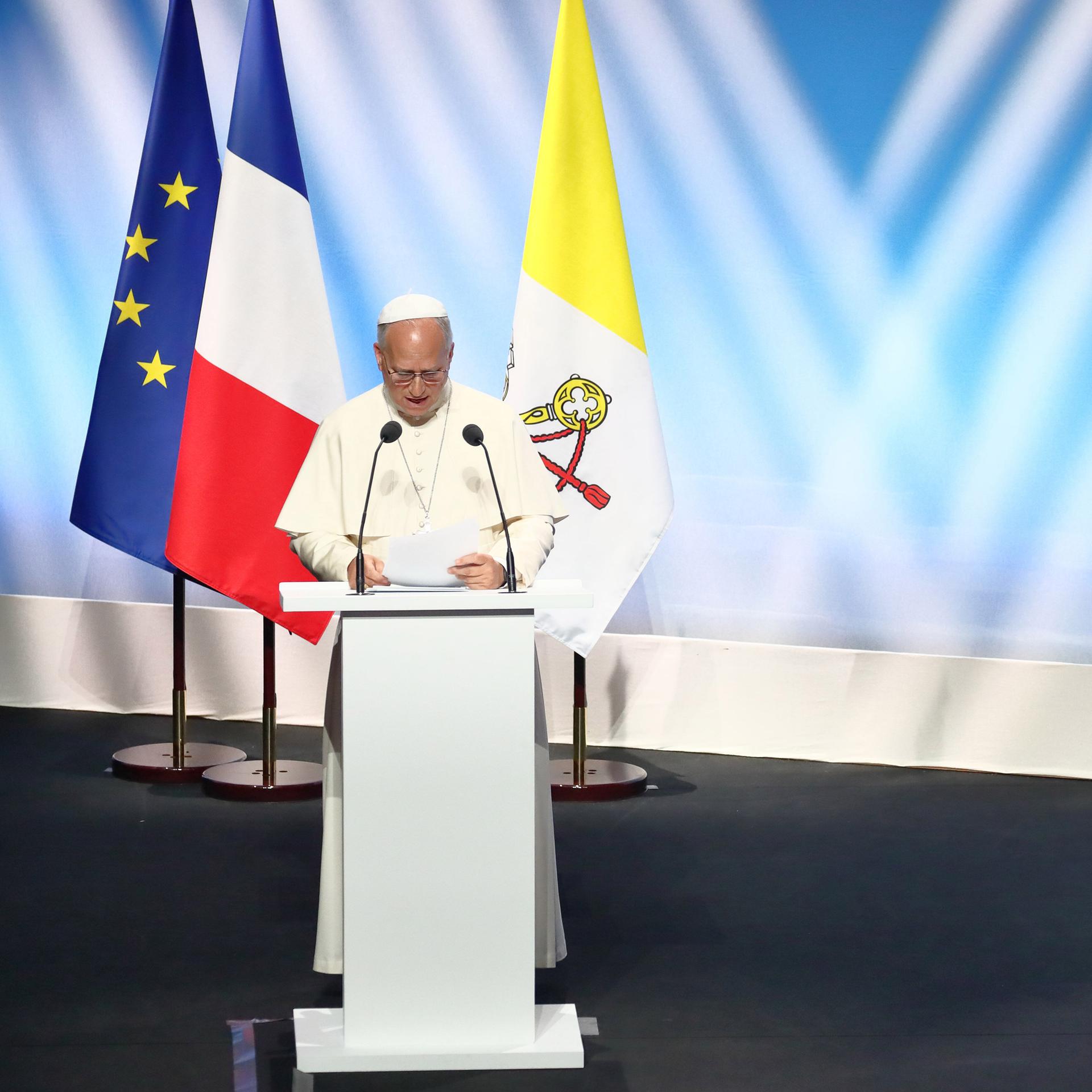 Papst Leo XIV bei einer Rede in Frankreich neben Präsident Macron