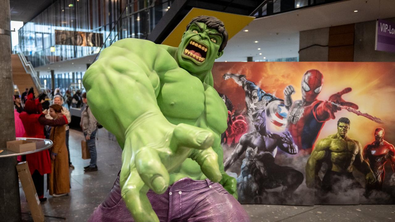 Große Hulk-Comicfigur vor einem Spiderman-Plakat und Besuchern auf der Comicmesse Comic Con in Stuttgart