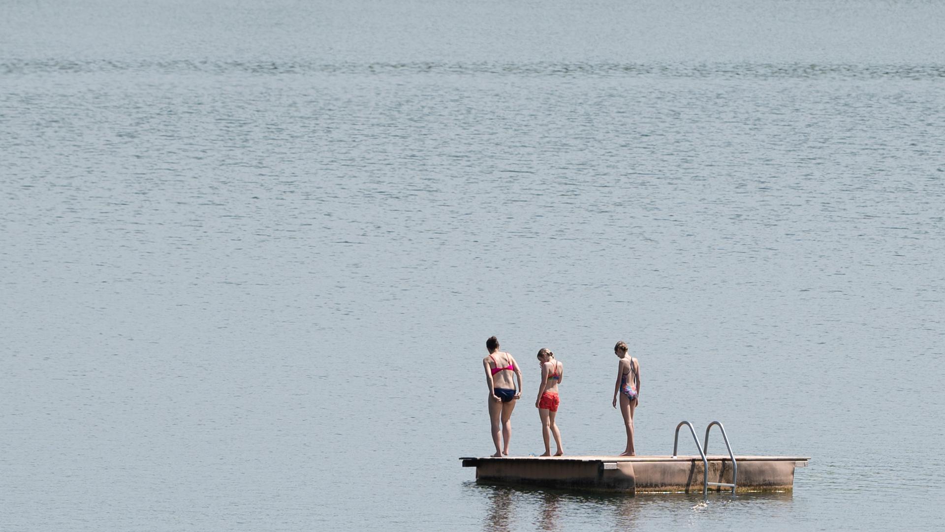 Pirna: Badegäste stehen im Badesee Birkwitz auf einer Badeinsel. 