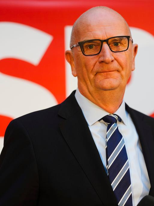 Brandenburgs Ministerpräsident Woidke vor dem roten Logo der SPD