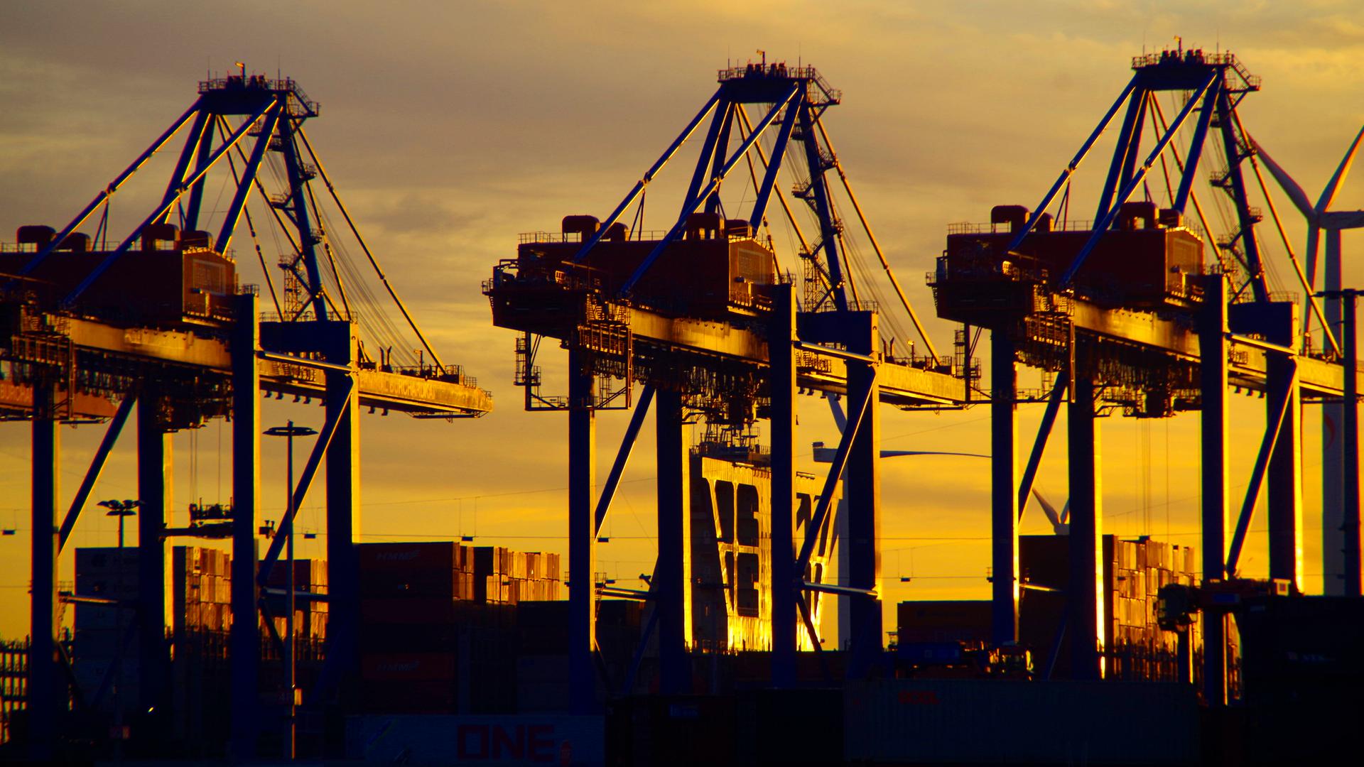 Zu sehen sind Containerbrücken vom Hamburger Hafen im Sonnenuntergang. Zu sehen sind Containerbrücken vom Hamburger Hafen im Sonnenuntergang.