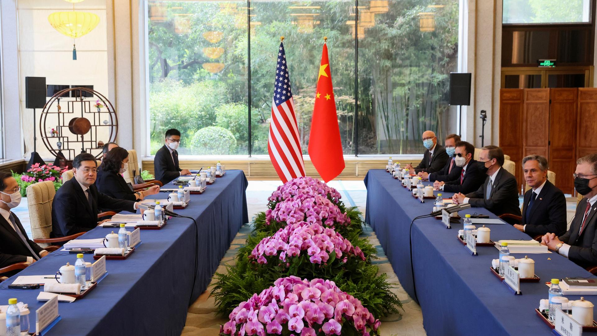 Das Foto zeigt US-Außenminister Antony Blinken und den chinesischen Außenminister Qin Gang. Sie sitzen mit ihren Delgationen an Tischen gegenüber. Im Hintergrund sind die Nationalflaggen Chinas und der USA.