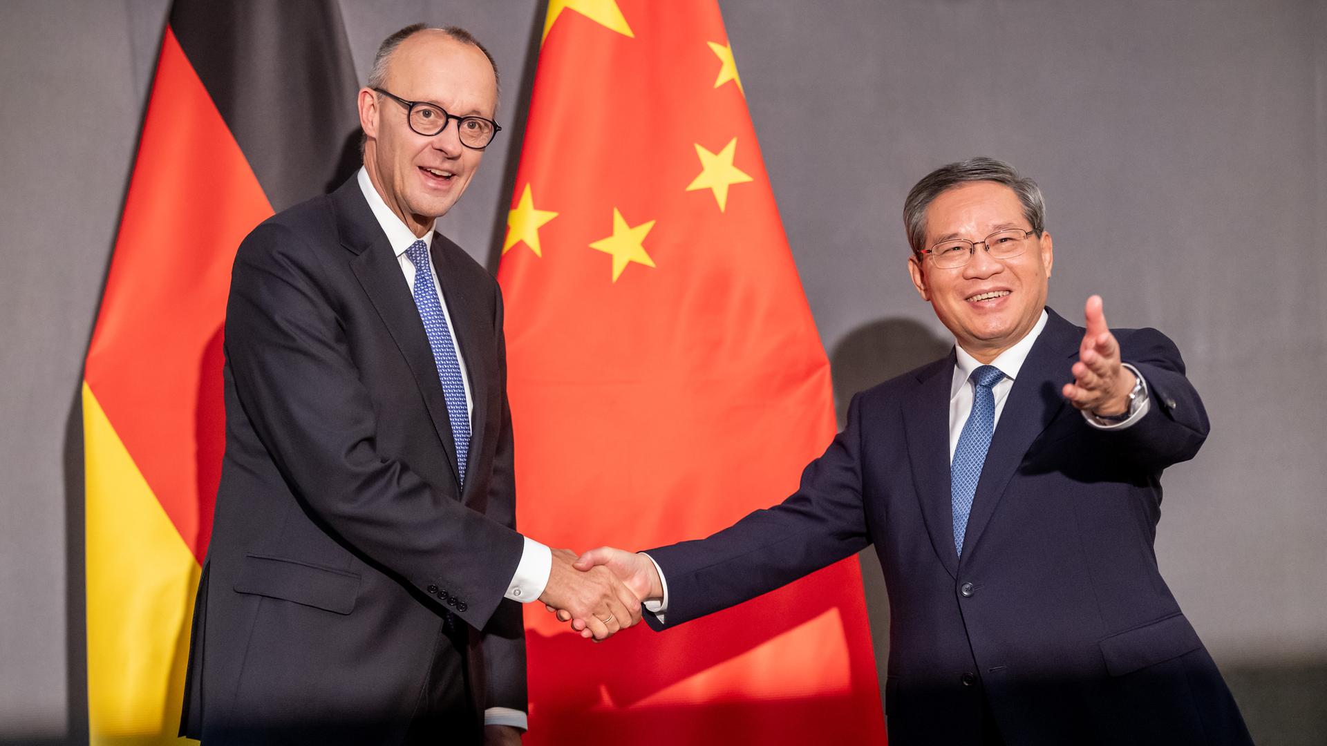 Bundeskanzler Friedrich Merz (CDU, l) und Li Qiang, Ministerpräsident von China, geben sich die Hände. Hinter ihnen sind die Flaggen Deutschlands und Chinas. Bundeskanzler Friedrich Merz (CDU, l) und Li Qiang, Ministerpräsident von China, geben sich die Hände. Hinter ihnen sind die Flaggen Deutschlands und Chinas.