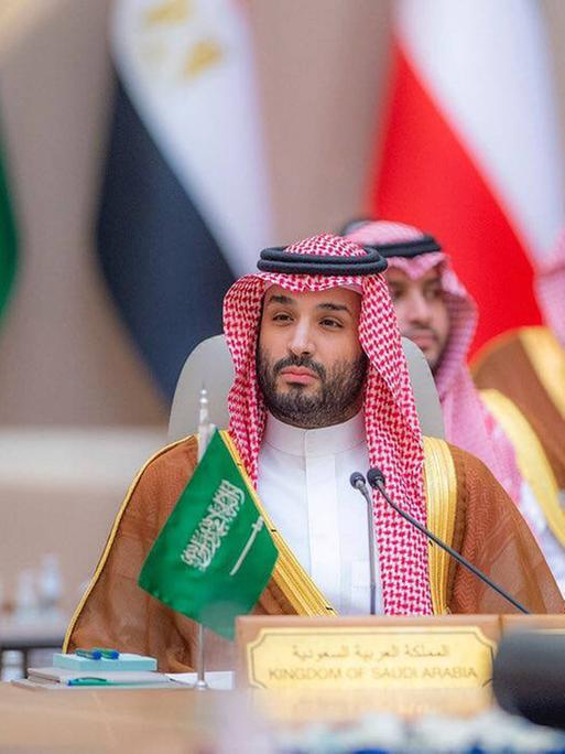 Der saudische Kronprinz Mohammed Bin-Salman sitzt auf eine Konferenz an einem Pult.