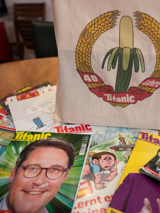 Eine Jubiläums-Stofftasche und einige Ausgaben des Satiremagazins "Titanic" liegen auf dem Konferenztisch in den Redaktionsräumen. Die Zeitschrift feiert im Oktober und November 2019 ihr 40-jähriges Bestehen.