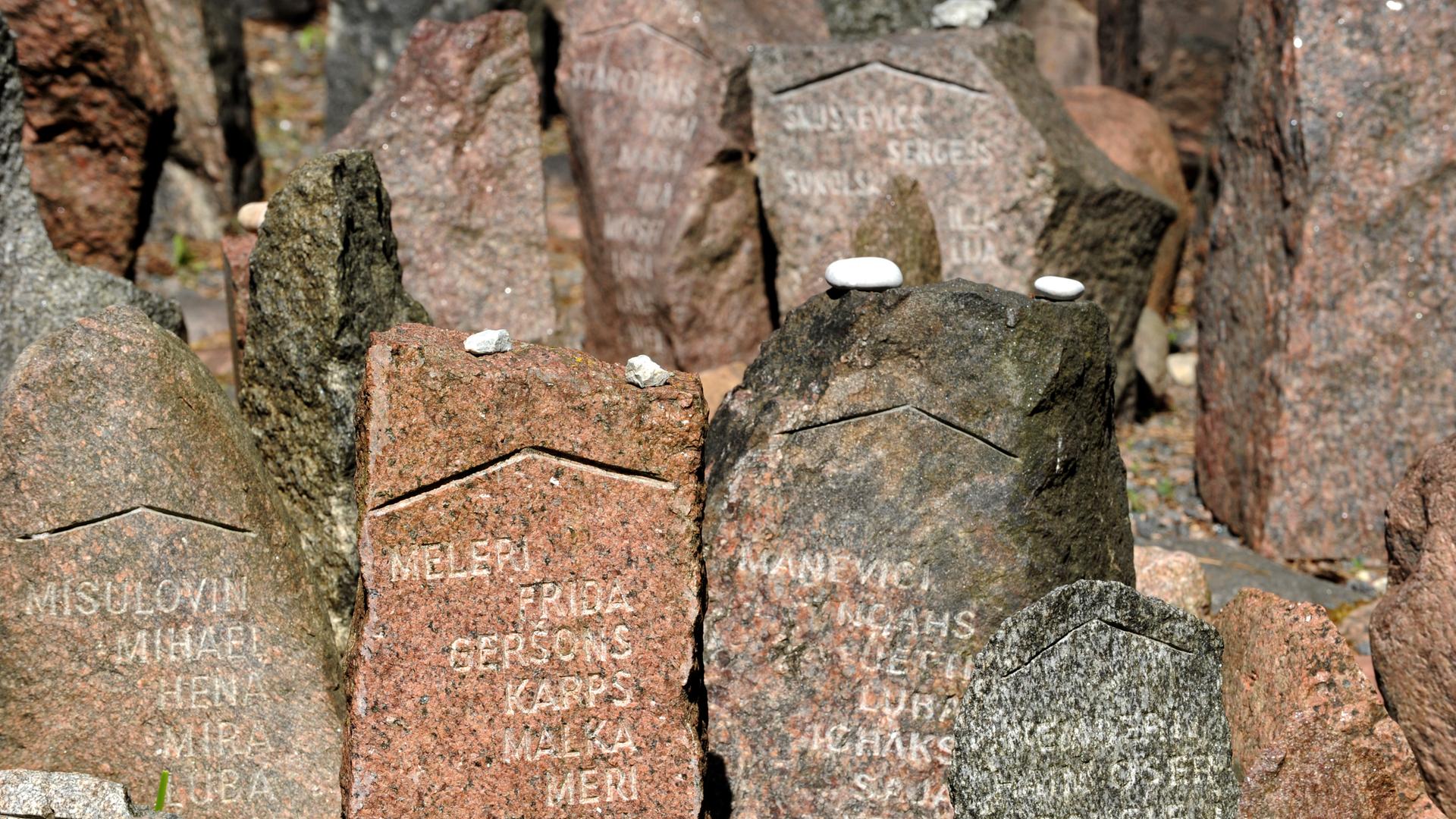 Mit Namen versehene Gedenksteine im Wald von Rumbula nahe Riga. An dieser Stelle erschossen deutsche Truppen 1941  mehr als 27.000 Jüdinnen und Juden