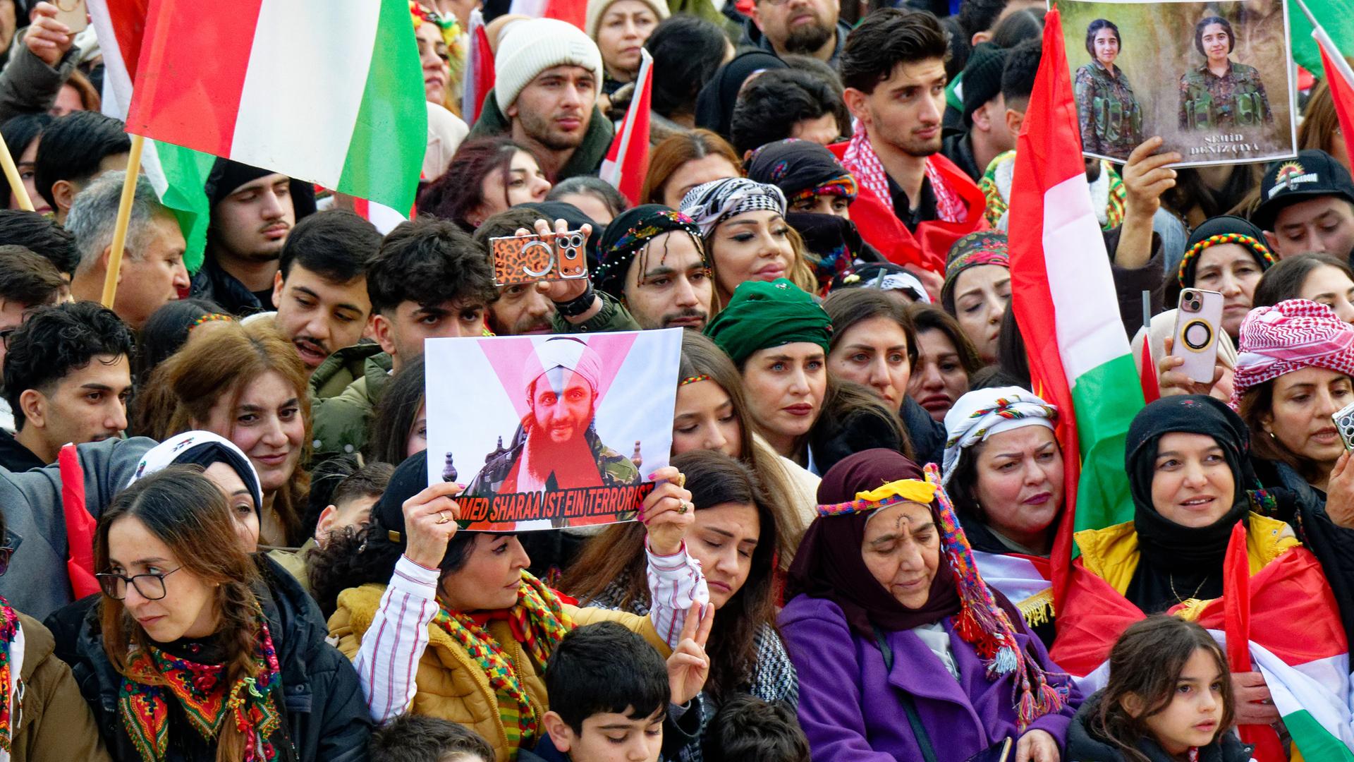 Teilnehmer einer Demonstration halten Fahnen hoch. Teilnehmer einer Demonstration halten Fahnen hoch.