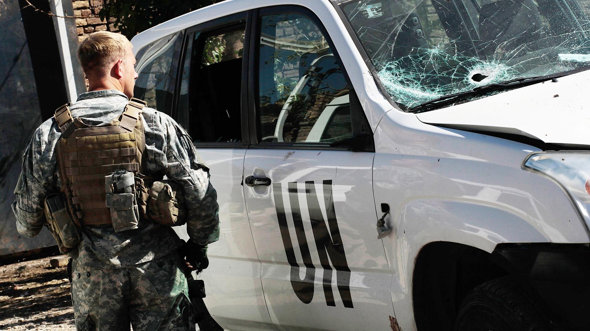 Ein amerikanischer UN Soldat steht neben einem Auto mit zerstörter Windschutzscheibe in Herat, Afghanistan, 2010.