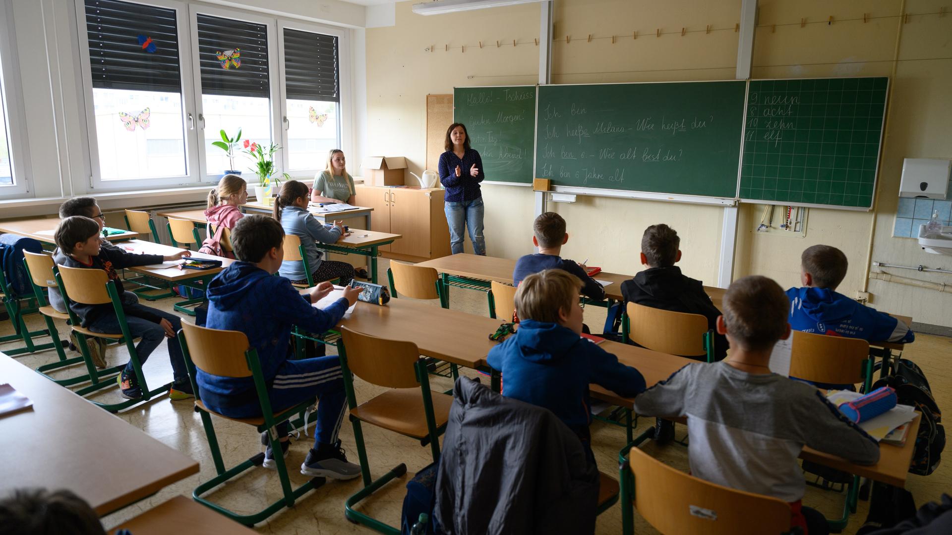 Grundschüler aus der Ukraine sitzen in der für ukrainische Kinder eröffneten Schule in einem Klassenzimmer.