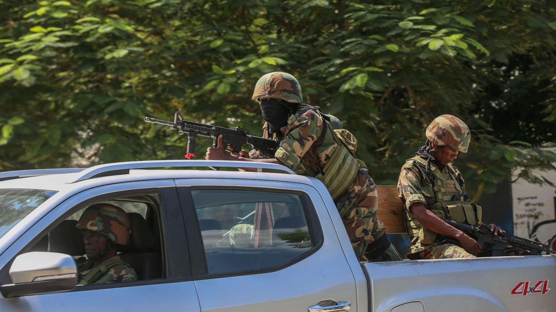 Soldaten sitzen mit Gewehren im Anschlag auf der Ladefläche eines Autos in Port-au-Prince in Haiti.