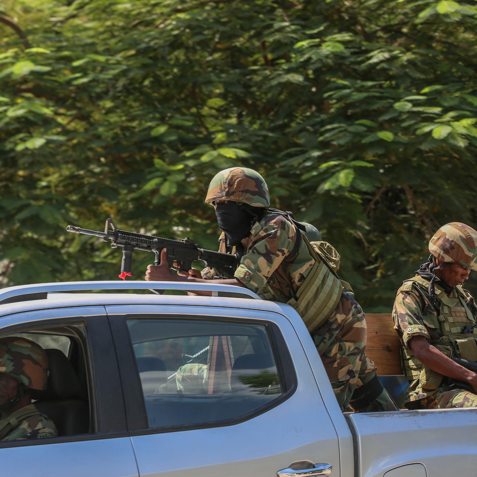 Soldaten sitzen mit Gewehren im Anschlag auf der Ladefläche eines Autos in Port-au-Prince in Haiti.
