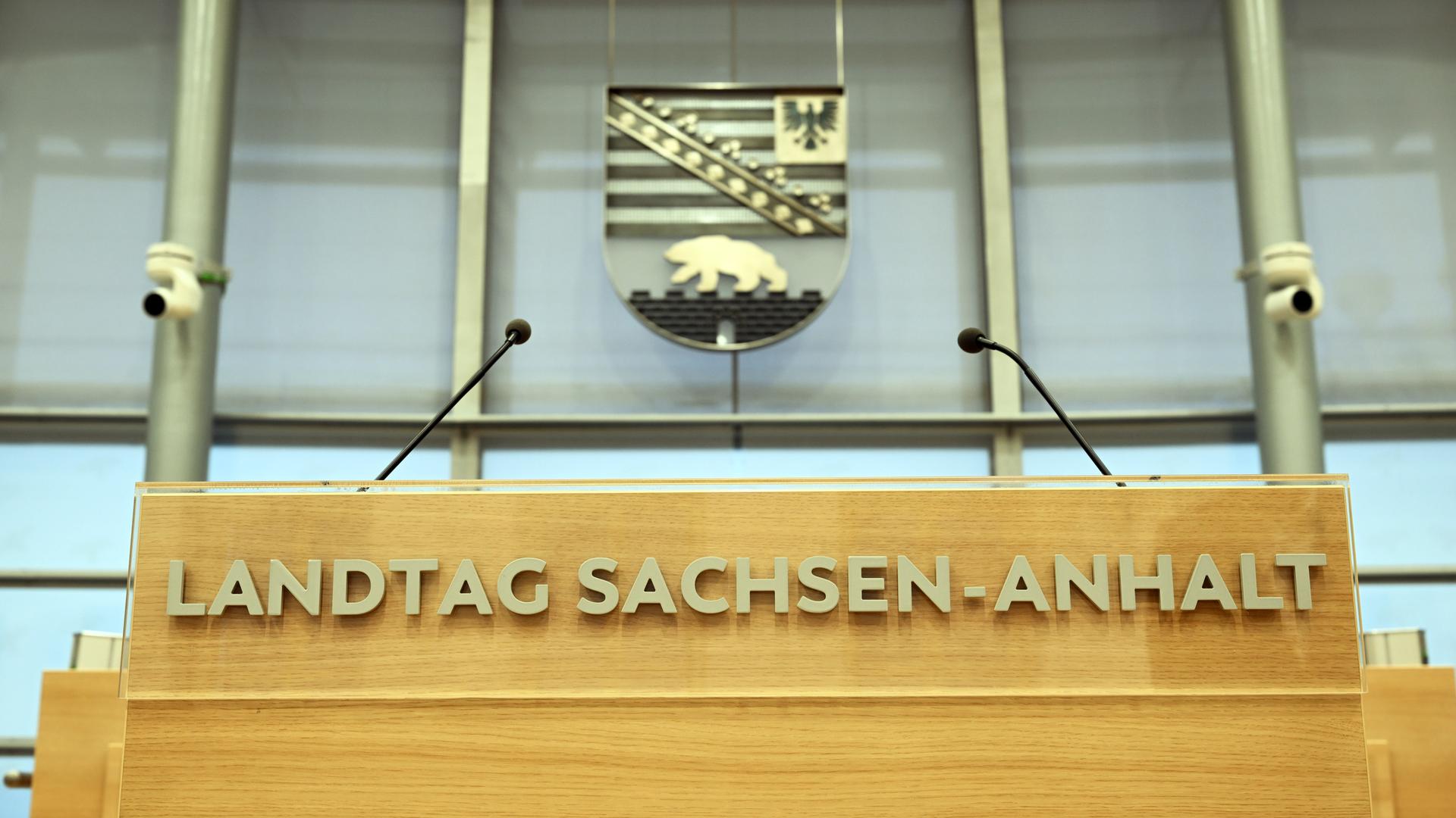 Hinter dem Rednerpult im Plenarsaal des Landtages von Sachsen-Anhalt hängt das sachsen-anhaltinische Wappen mit Adler und Bär. Hinter dem Rednerpult im Plenarsaal des Landtages von Sachsen-Anhalt hängt das sachsen-anhaltinische Wappen mit Adler und Bär.
