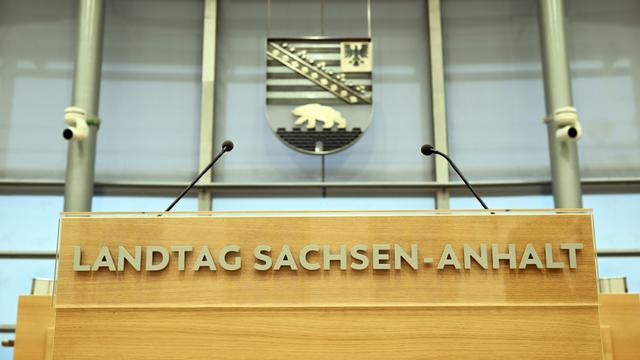 Hinter dem Rednerpult im Plenarsaal des Landtages von Sachsen-Anhalt hängt das sachsen-anhaltinische Wappen mit Adler und Bär. Hinter dem Rednerpult im Plenarsaal des Landtages von Sachsen-Anhalt hängt das sachsen-anhaltinische Wappen mit Adler und Bär.