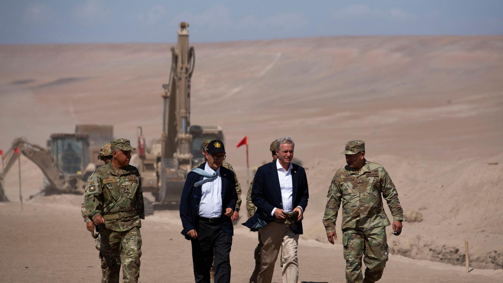 Chiles Präsident Kast begutachtet die Arbeiten entlang der Grenze zu Peru, im Hintergrund sind Baugeräte.