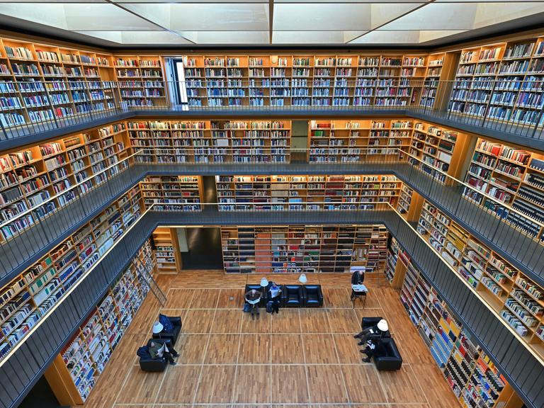 Foto in eine große Bibliothek. Auf mehreren Etagen sind Bücher in Regalen sortiert. Der Bücherkubus befindet sich im Studienzentrum der Herzogin Anna Amalia Bibliothek in Weimar.