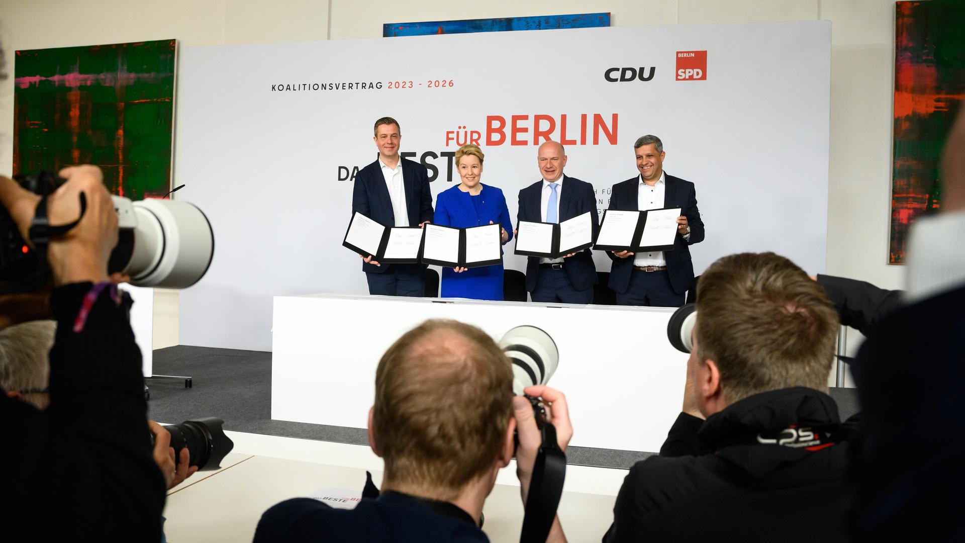 Franziska Giffey (2.v.l., SPD), , Kai Wegner (2.v.r., CDU), Raed Saleh (r, SPD) und Stefan Evers (l, CDU) halten jeweils einen Koalitionsvertrag in die Kameras vieler Fotografen 