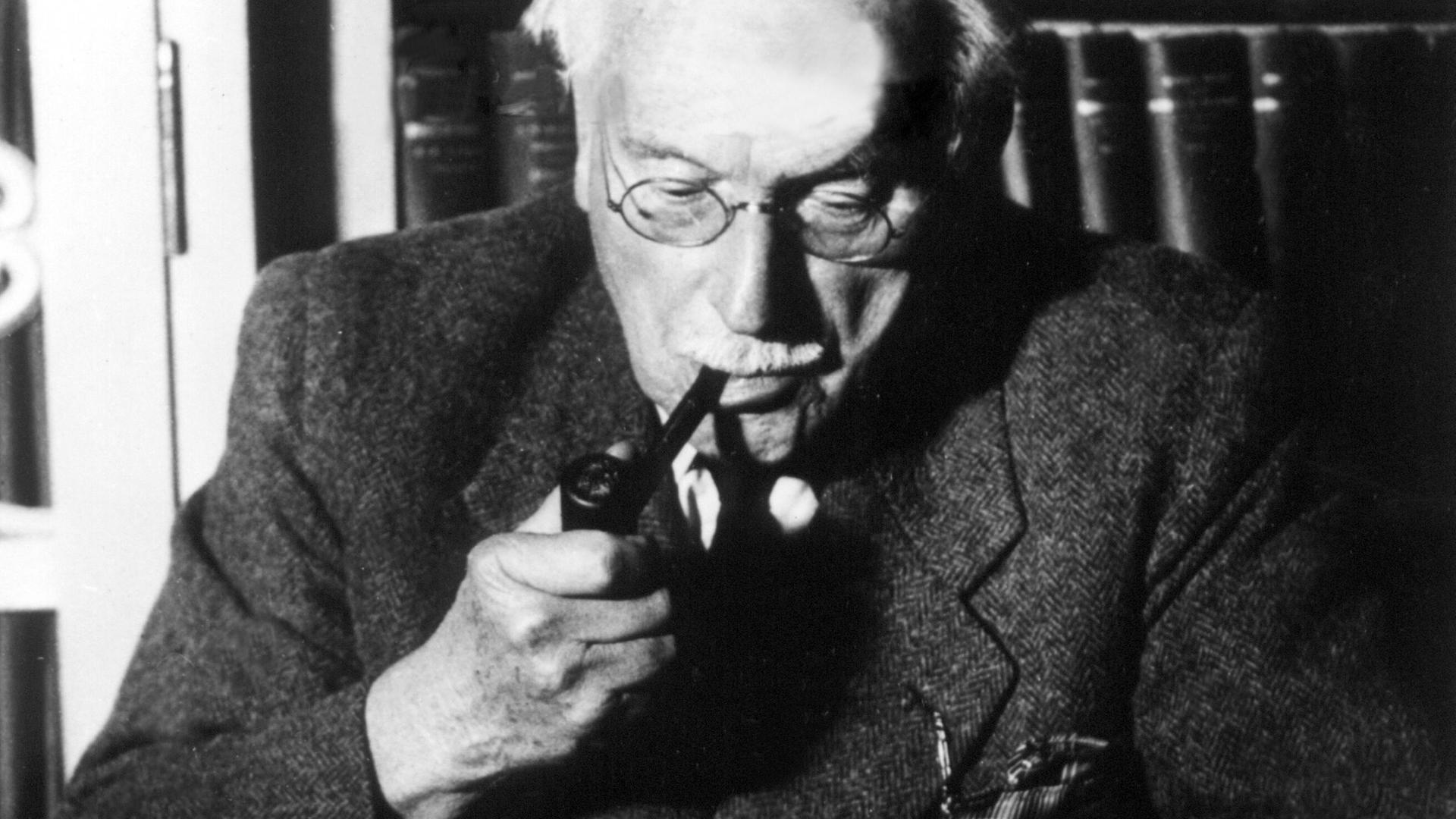 Der Schweizer Psychologe und Psychiater Carl Gustav Jung sitzt vor Unterlagen an seinem Schreibtisch. (undatierte Aufnahme)