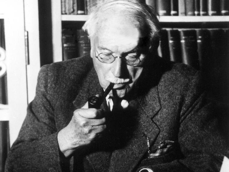 Der Schweizer Psychologe und Psychiater Carl Gustav Jung sitzt vor Unterlagen an seinem Schreibtisch. (undatierte Aufnahme)