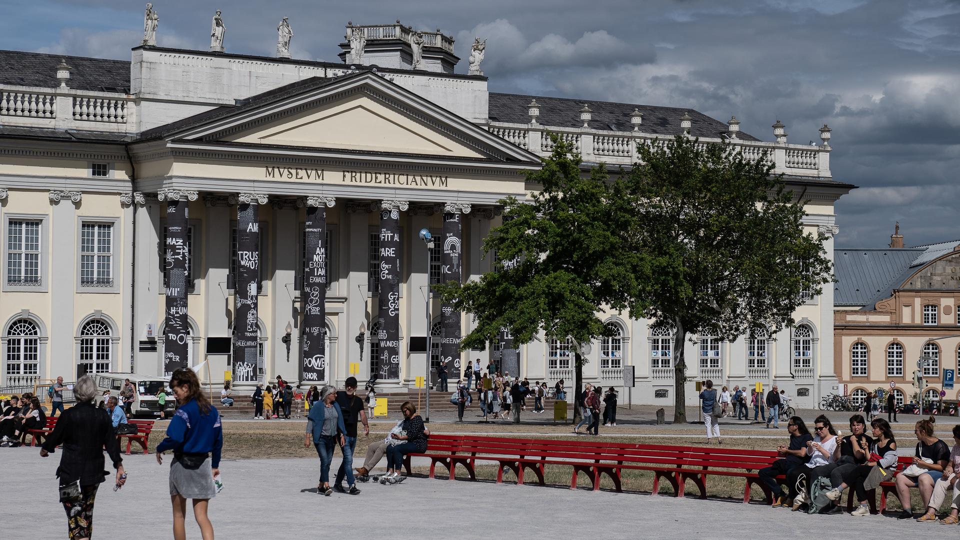 Besucher der documenta fifteen stehen vor dem Museum Fridericianum in Kassel. 