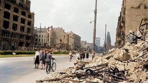 Nachkriegsdeutschland: Die Tauentzienstraße in Berlin. Straßenbild mit Kriegszerstörungen; im Hintergrund die Kaiser-Wilhelm-Gedächtniskirche, links die Ruine des KaDeWe. Foto um 1948, digital koloriert.