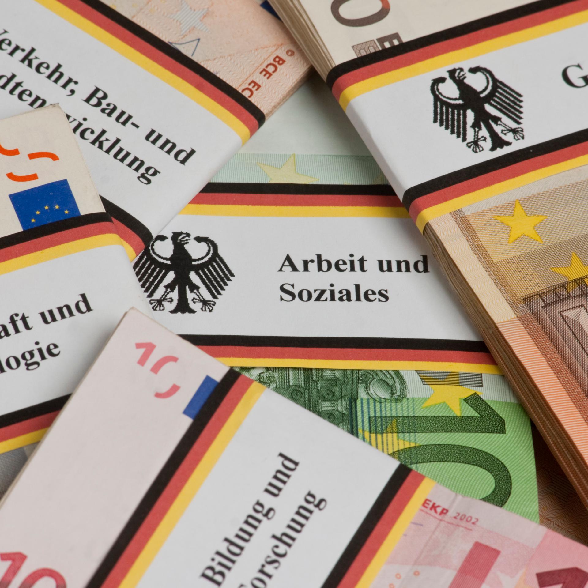 Symbolfoto Bundeshaushalt: Geldbündel mit schwarz-rot-goldener Banderole und Bundesadler