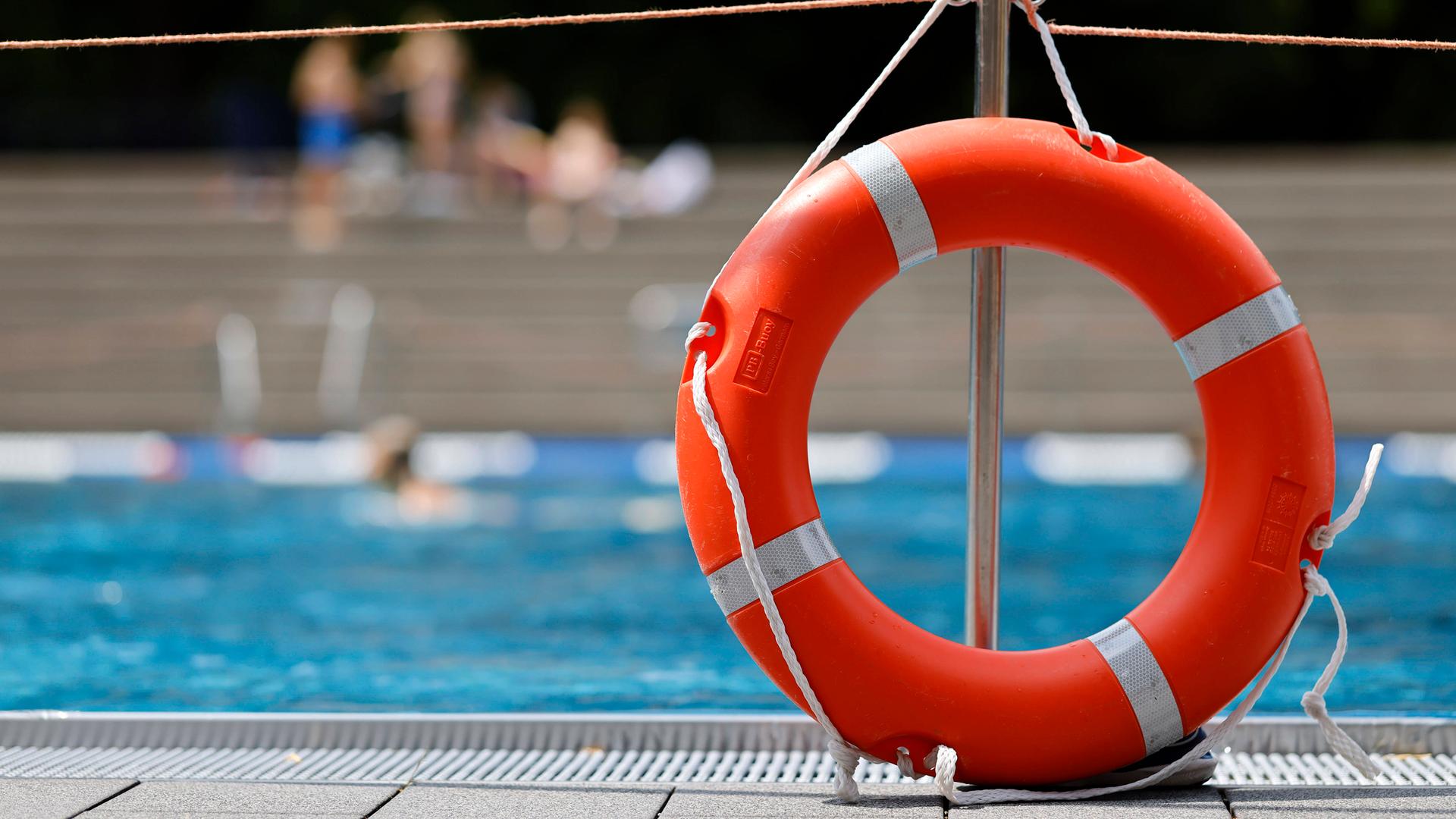 Zu sehen ist ein Rettungsring am Rand eines Schwimmbad-Beckens.