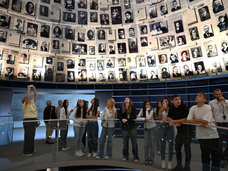 Besucher in Yad Vashem stehen unter einer Kuppel mit Fotos von NS-Opfern