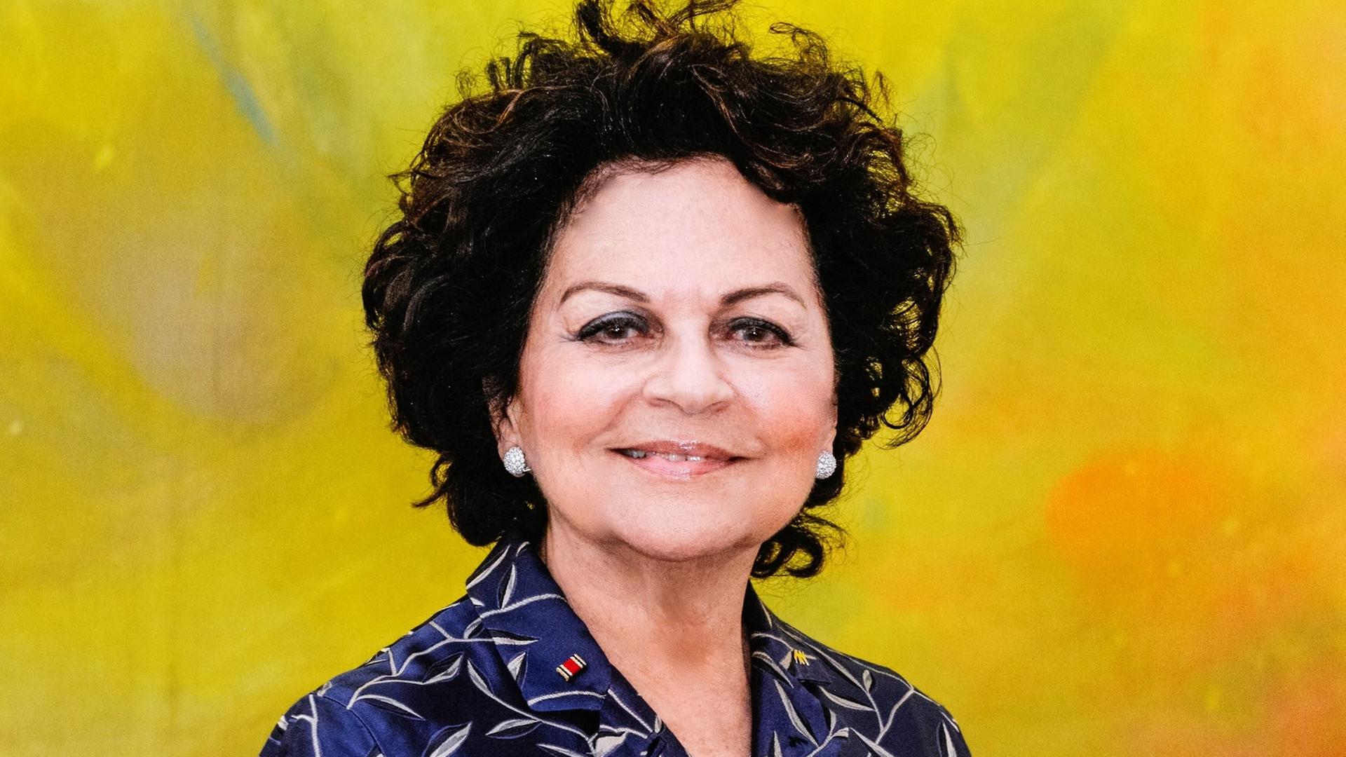 Sonja Lahnstein-Kandel lächelt in die Kamera. Sie trägt das dunkle Haar in kurzen Wellen und einen dunkelblauen Blazer mit silbernem Rankenmuster.