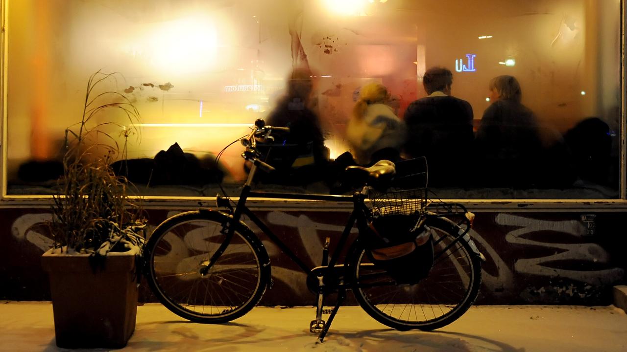 Ein Fahrrad steht vor einer Kneipe mit beschlagenen Fenstern. 