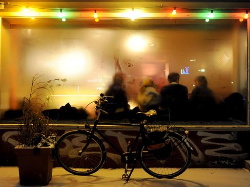 Ein Fahrrad steht vor einer Kneipe mit beschlagenen Fenstern. 