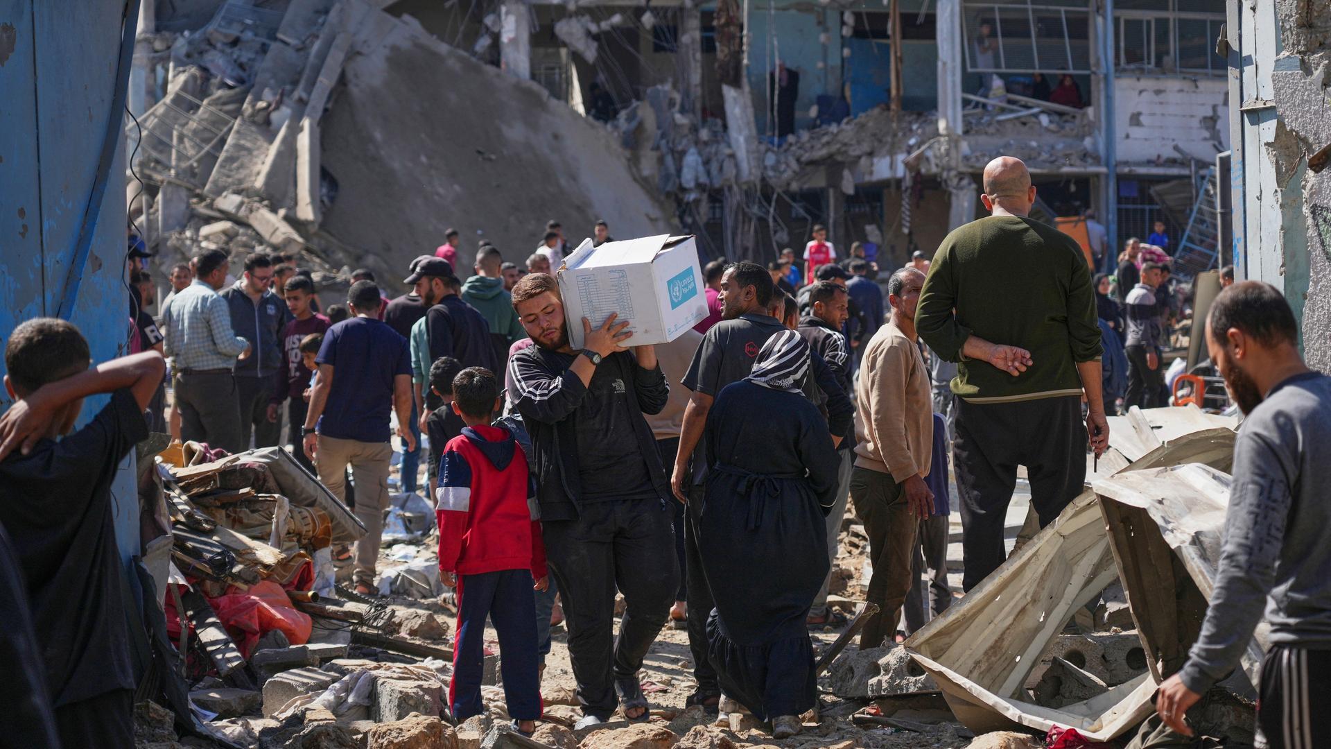 Palästinenser sammeln Habseligkeiten aus einer Schule in Al-Bureidsch, die als Unterkunft für Vertriebene diente und am Dienstag zweimal von der israelischen Armee angegriffen wurde, wobei mehrere Menschen getötet wurden. Palästinenser sammeln Habseligkeiten aus einer Schule in Al-Bureidsch, die als Unterkunft für Vertriebene diente und am Dienstag zweimal von der israelischen Armee angegriffen wurde, wobei mehrere Menschen getötet wurden.