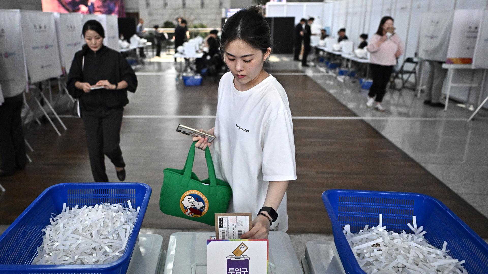 Eine Frau wirft im Flughafen von Incheon in Südkorea ihren Stimmzettel für die Präsidentenwahl in eine Wahlurne. 