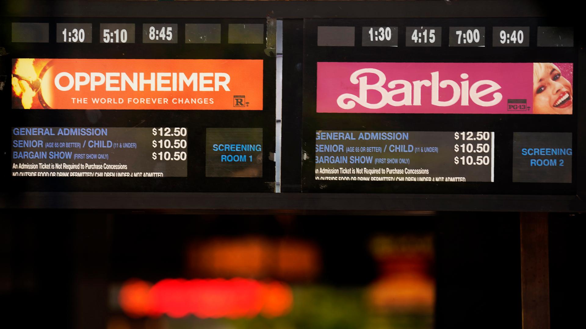 Auf einer Anzeigentafel sind die beiden Filme "Oppenheimer" und "Barbie" annonciert.