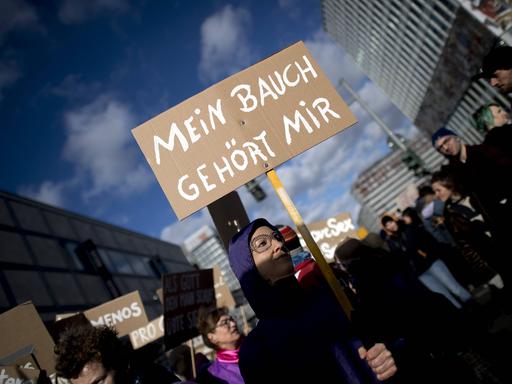 Eine Person hält auf einer Demo ein Schild in der Hand, auf dem "Mein Bauch gehört mir" steht.