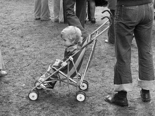 Ein Kind sitzt in einem Kinderwagen.