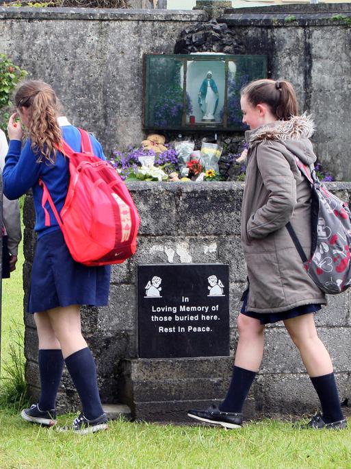 Schülerinnen auf dem Weg zu der Gedenkstätte auf dem Friedhof in Tuam, Irland. Zum Gedenken an die 796 Babies und Kinder, deren Überreste auf dem Gelände des ehemaligen katholischen Heims für unverheiratete Mütter vermutet werden.