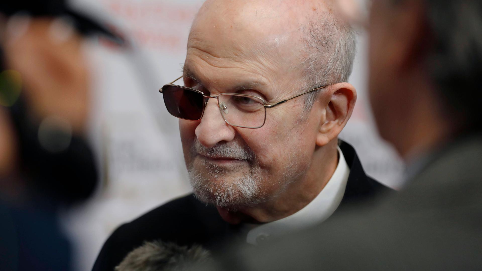 Salman Rushdie. Seine Brille hat ein schwarzes Glas vor dem blinden Auge.
