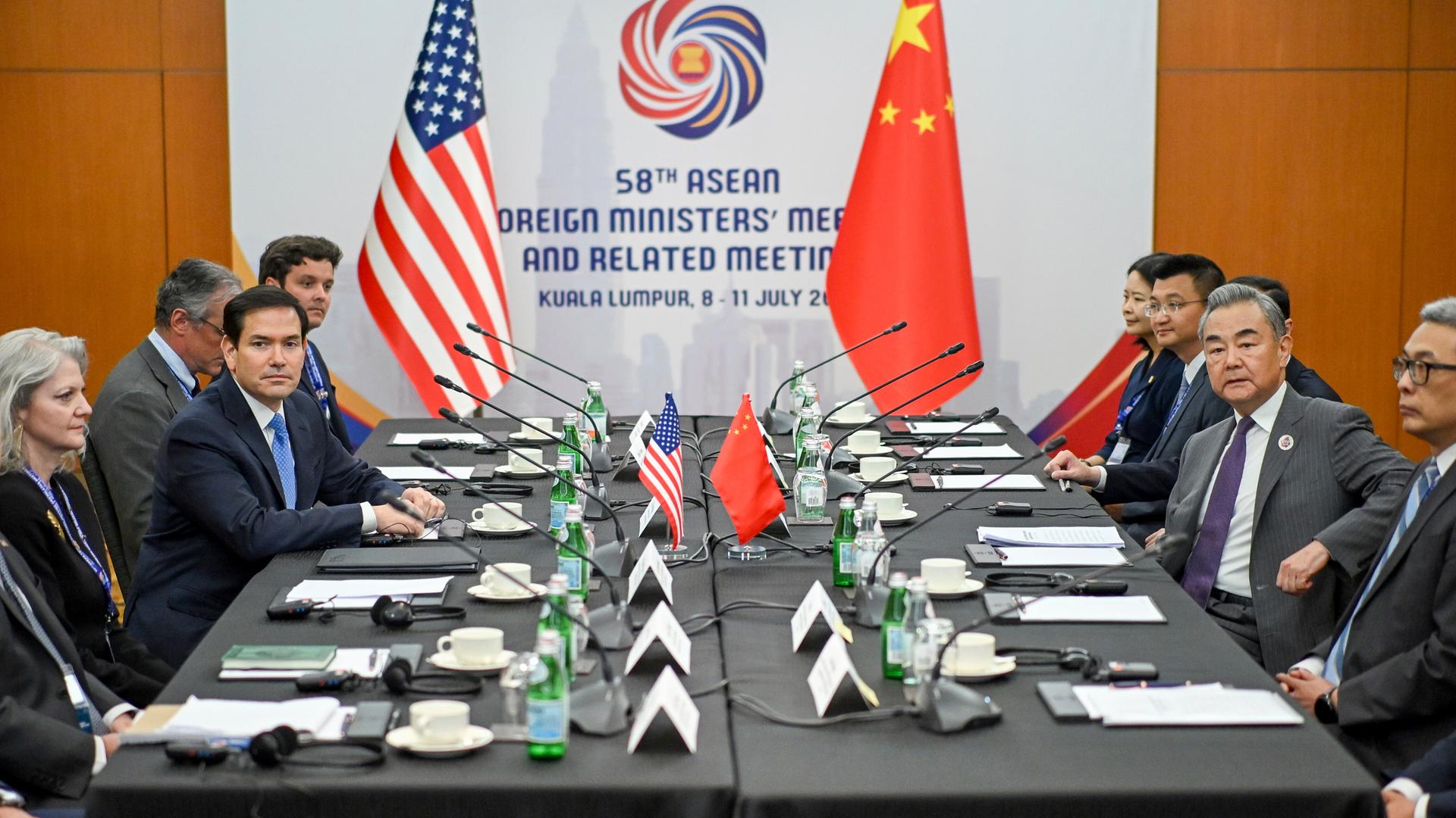 US-Außenminister Rubio und Chinas Außenminister Wang sitzen sich an einem großen Tisch gemeinsam mit ihren Delegationen gegenüber.